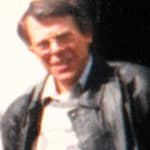 Mann mit Brille und Lederjacke, der lächelt und in die Kamera schaut.