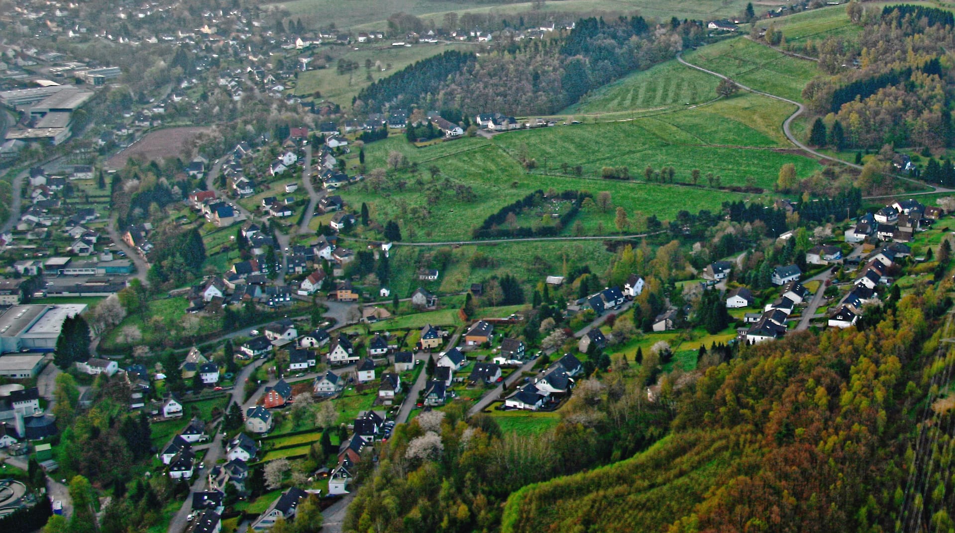 Luftbild von Erbland und Schönenberg mit Wohngebieten und landwirtschaftlichen Flächen.