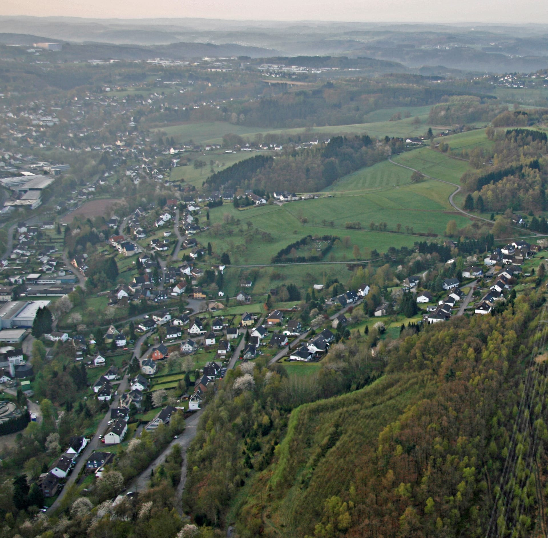 Luftbild von Erbland und Schönenberg mit Wohngebieten und landwirtschaftlichen Flächen.